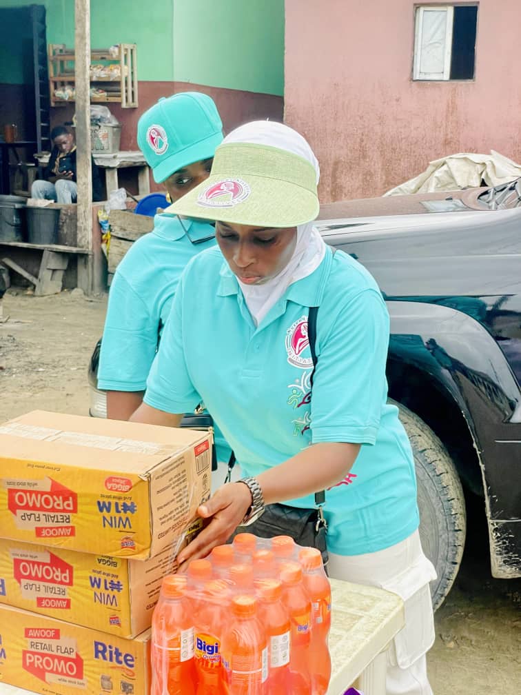 Two Serenity Sisterhood volunteers in teal shirts unpacking cartons of supplies